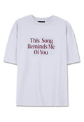 Kurze Ärmel, weißes Baumwoll-T-Shirt mit burgunderfarbenem Text: "Dieses Lied erinnert mich an dich" in einer fett gedruckten Serifenschrift.