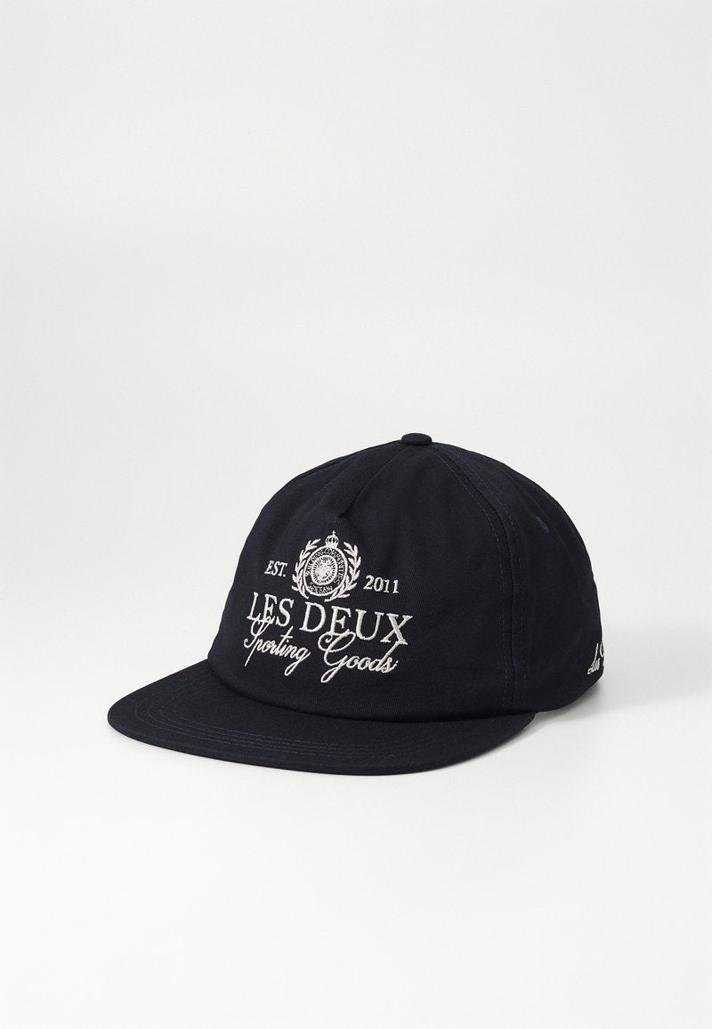 Marineblaue Mütze aus Baumwolle mit strukturiertem Design. Verfügt über gestickten Text "LES DEUX Sporting Goods" und ein Logo auf der Vorderseite.