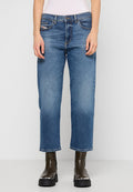 Helle Jeans aus Denim mit geradem Schnitt, mittelhoher Taille, Fronttaschen und leichter Ausbleichung; kombiniert mit schwarzen Stiefeletten.