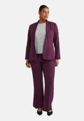 Lila Blazer und passende weit geschnittene Hose, kombiniert mit einem grauen gerippten Oberteil. Das Material scheint strukturiert zu sein, mit einer glatten Textur und einfachen Designelementen.
