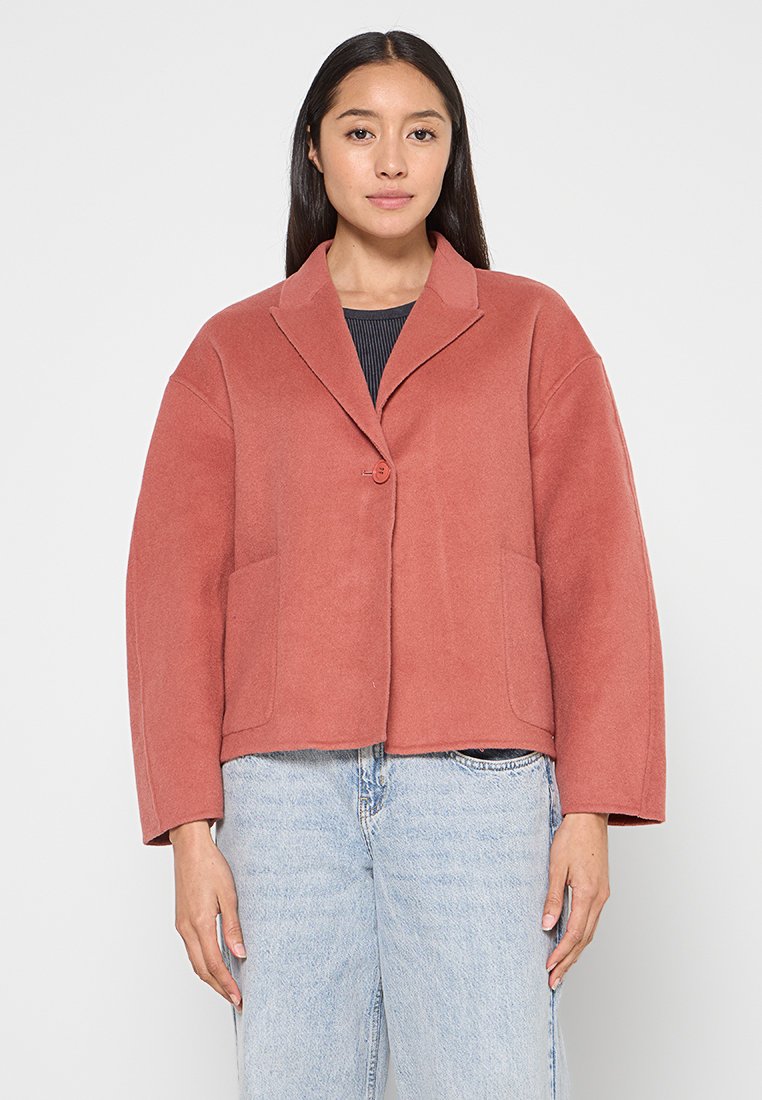 Kürzerer, rostfarbener Blazer aus weichem Stoff, mit spitzem Kragen, einem Knopfverschluss und zwei vorderen Taschen.