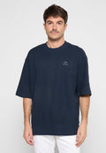 Navy-blaues T-Shirt mit kurzen Ärmeln und Rundhalsausschnitt aus strukturiertem Stoff, mit einem Logopatch auf der Brust und einem gerippten Saum am unteren Ende.