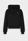 Schwarze, kurze Kapuzenjacke aus weichem Stoff mit einer Fronttasche. Verfügt über eine Kordelzugkapuze und einem kleinen Logo-Patch auf der oberen linken Seite.