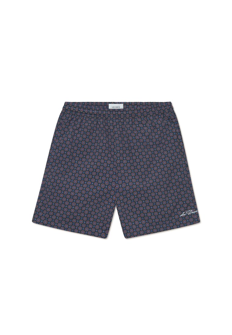 Marineblaue Shorts mit einem geometrischen Muster aus roten und blauen Kreisen. Elastischer Bund mit einem kleinen Logo-Patch unten rechts. Leichtes Material.