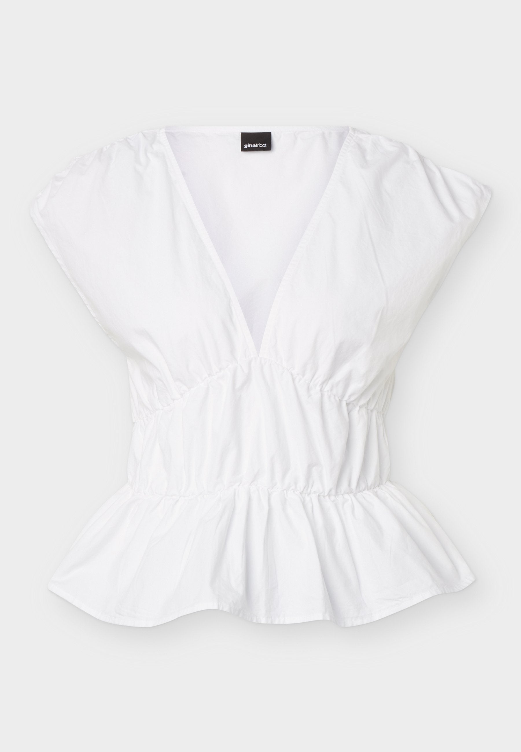 Weiße kurzärmelige Bluse mit tiefem V-Ausschnitt, elastischer Taille und Schößchen-Saum, flach auf weißem Hintergrund ausgelegt.
