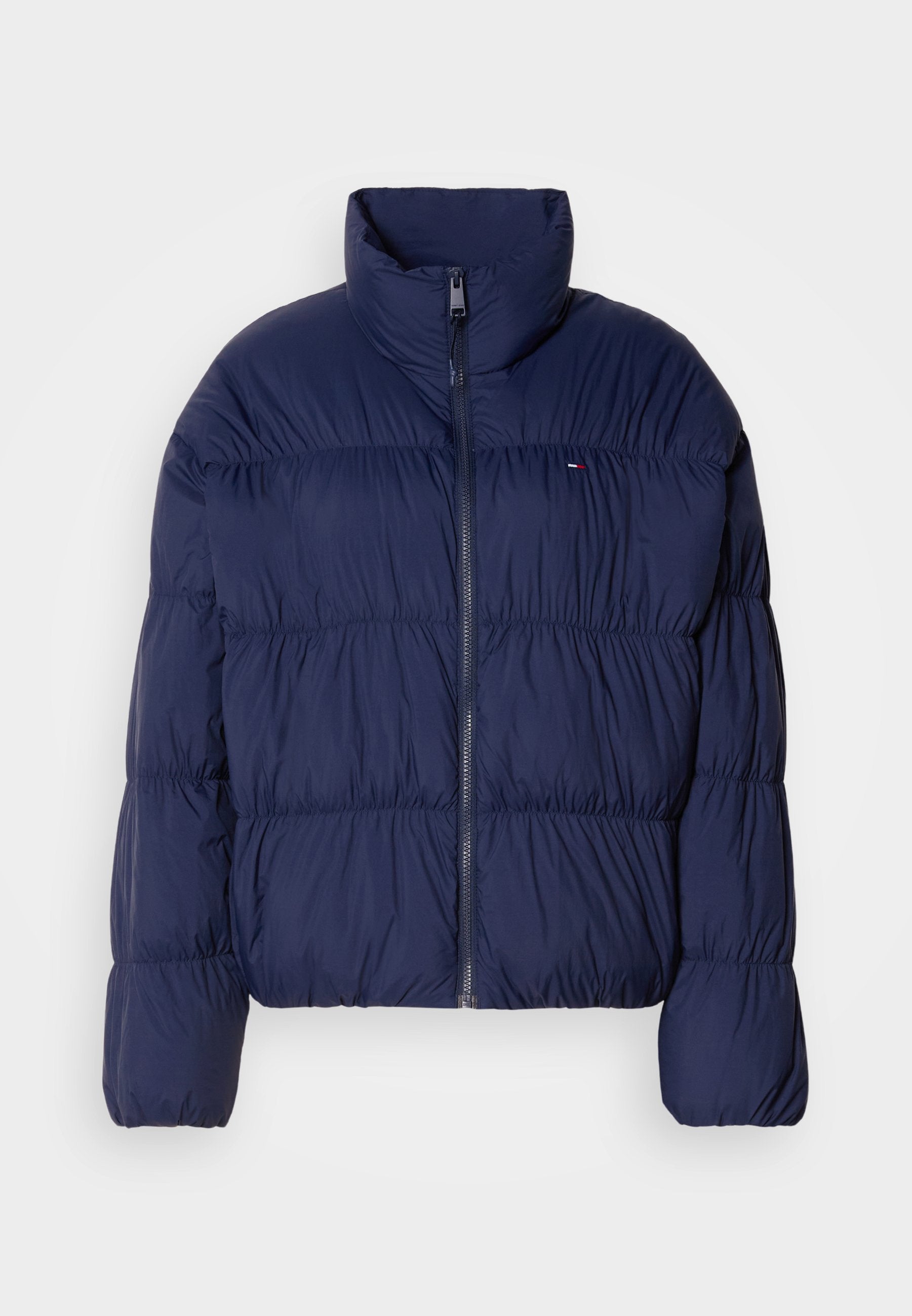 Marineblaue Steppjacke mit hohem Kragen, Reißverschluss, gesteppter Optik und elastischen Bündchen. Verfügt über ein kleines Logo auf der linken Brust.