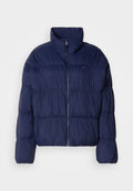 Marineblaue Steppjacke mit hohem Kragen, Reißverschluss, gesteppter Optik und elastischen Bündchen. Verfügt über ein kleines Logo auf der linken Brust.
