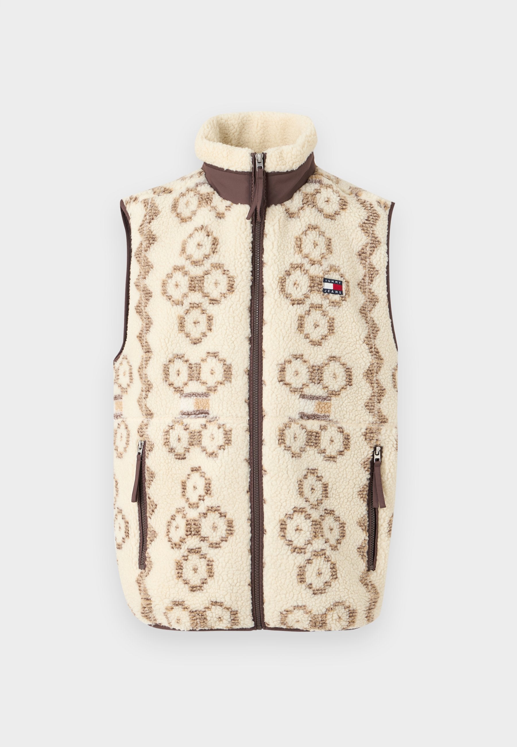 Fleece-Weste mit cremefarbener Basis, braunem geometrischen Muster und durchgehendem Reißverschluss. Sie verfügt über Seitentaschen und einen hohen Kragen.