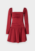 Rotes Kleid mit langen Ärmeln, einem quadratischen Ausschnitt und geraffter Stoffstruktur entlang des Oberteils; endet in einem plissierten Rock.