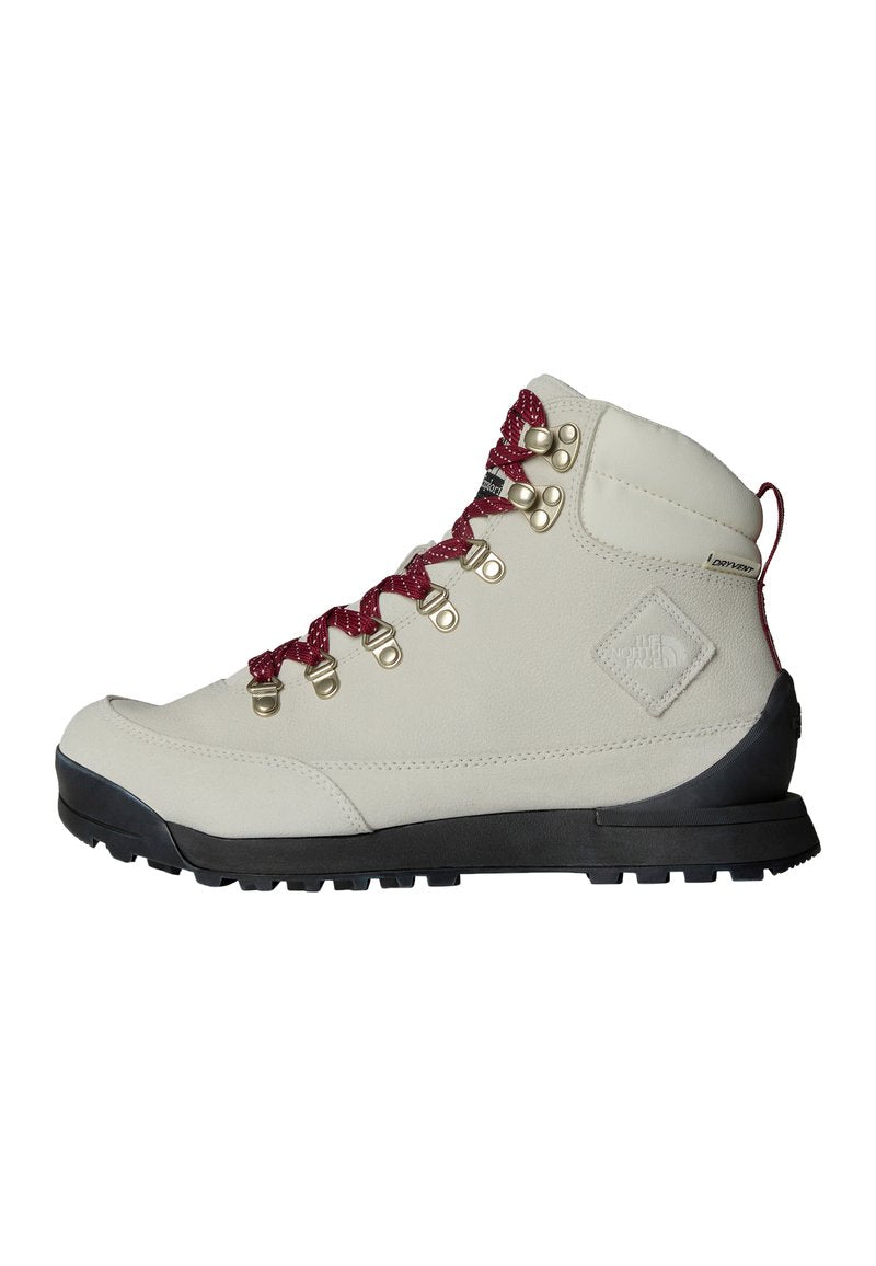 Beige Wanderschuh mit roten Schnürsenkeln, Metallösen und strukturiertem Obermaterial. Besitzt eine robuste schwarze Sohle und ein auffälliges Logo-Detail an der Seite.