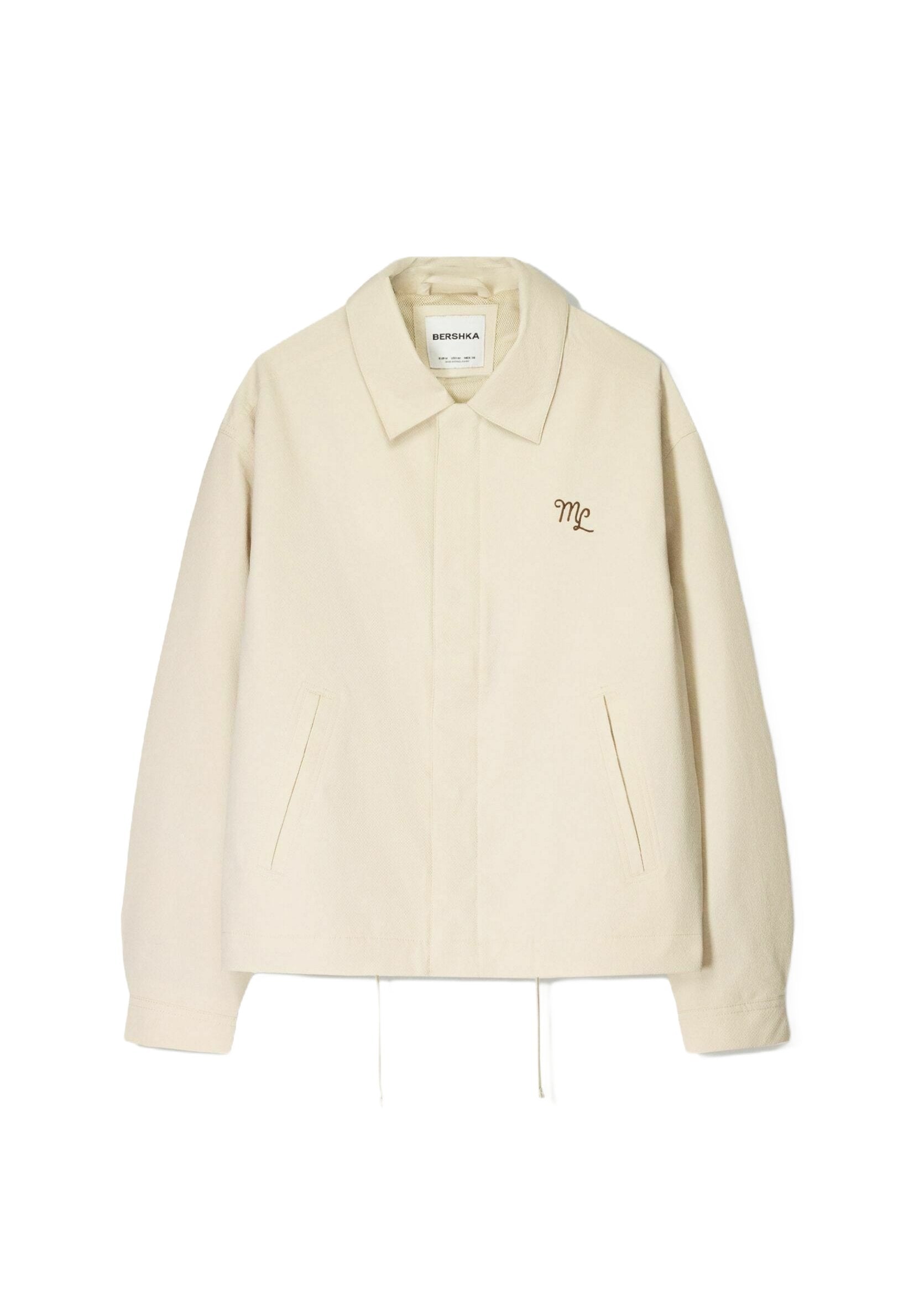 Cremefarbener Jacke mit Kragen, vorderen Taschen und einem Kordelzugsaum. Mit dezenten, braunen gestickten Initialen "ML".