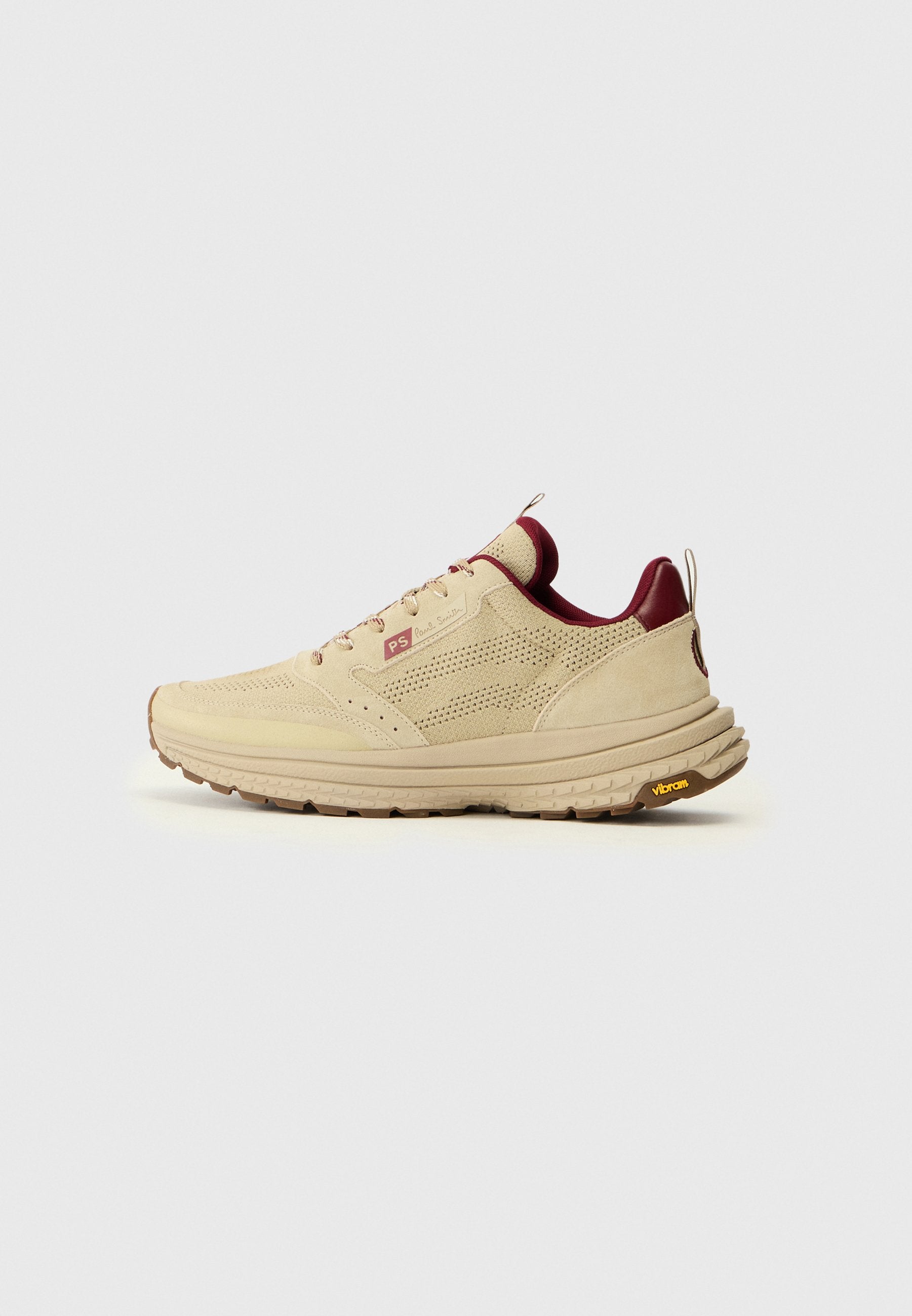 Beige Wildleder-Sneaker mit perforierten Details, bordeauxroten Akzenten und einer strapazierfähigen Sohle mit Vibram-Logo. Schnürsenkel und eine Schlaufenzugschlaufe sind enthalten.