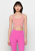 Rosa Sport-BH mit quadratischem Ausschnitt und breiten Trägern, kombiniert mit hochtaillierten rosa Leggings mit einem kleinen Logo. Glatter Stoffeindruck.
