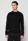 Schwarzer gestrickter Pullover mit langen Ärmeln, strukturierter Passe und gerippten Bündchen. Hergestellt aus weichem Stoff, mit Rundhalsausschnitt und lockerem Sitz.