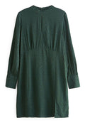 Dunkelgrünes Kleid aus glattem Stoff, mit einem dezenten Tiermotiv-Muster, langen Ärmeln und einem seitlichen Schlitz.