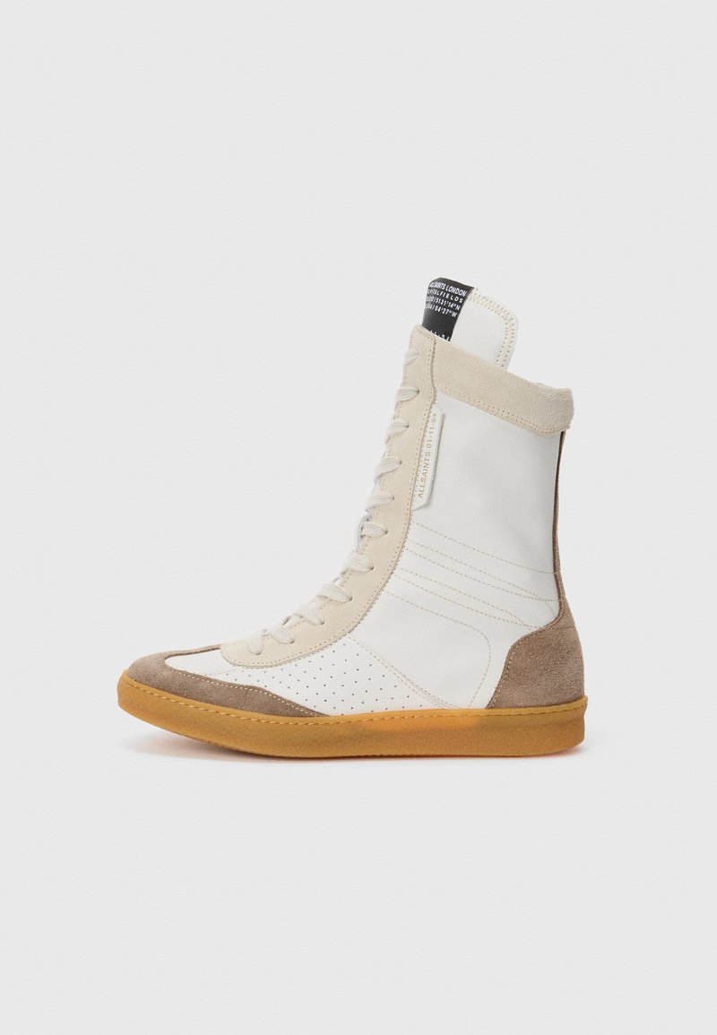 Hochformat Sneaker aus einer Kombination von glattem weißen Leder und senfgelbem Wildleder, mit perforierten Details, beigen Schnürsenkeln und einer Gummisohle.