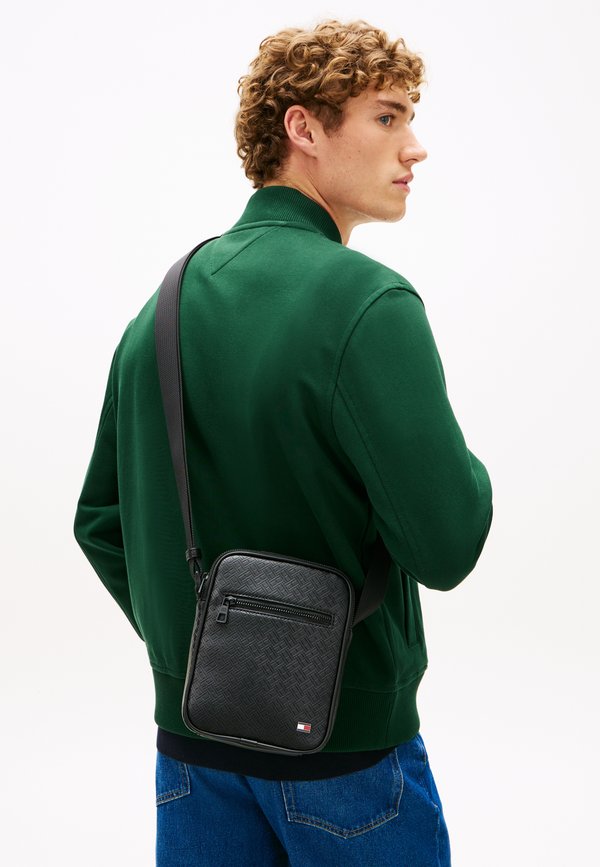 Tommy Hilfiger EMBOSSED FLAG CROSSBODY REPORTER BAG - Cross body bag - black