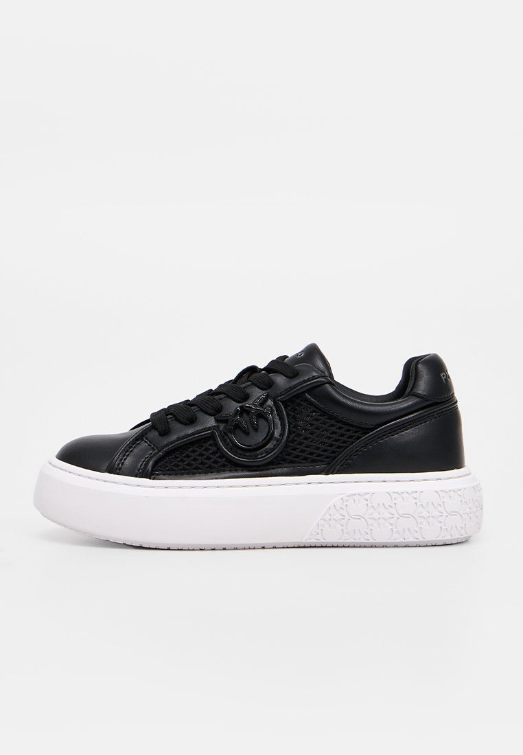 Schwarzer Leder- und Mesh-Sneaker mit dicker weißer Sohle und gebrandetem kreisförmigem Logo an der Seite, in der Seitenansicht gezeigt.