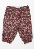 Blumenmusterte, kastanienbraune Hose mit elastischem Bund und Bündchen, die kleine rosa und crèmefarbene Blumen auf einem dunklen Hintergrund zeigt.