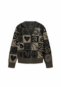 Geknöpfter Strickcardigan mit schwarzem und beige kariertem Muster, das Friedenszeichen, gebrochene Herzen, Sicherheitsnadeln, Spinnweben und das Motiv des Buchstabens "A" zeigt.