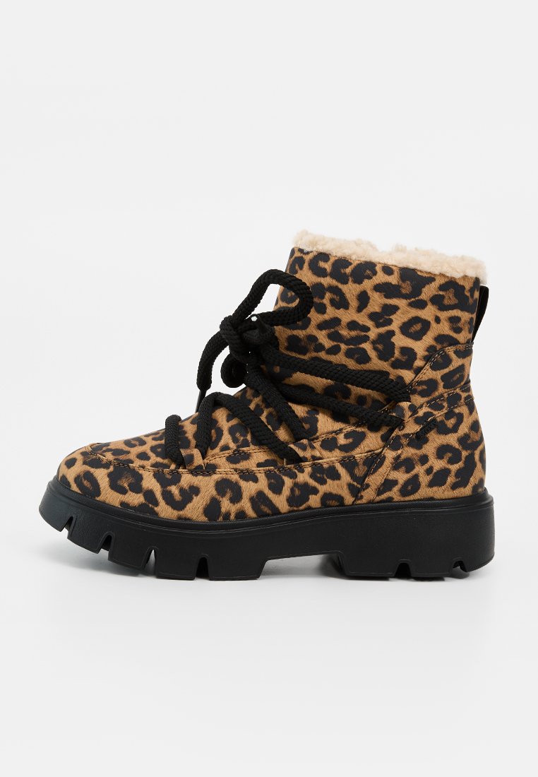 Schnürstiefelette mit Leopardenmuster, dicker schwarzer Sohle und beigem Kunstpelzfutter.