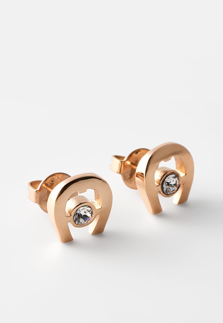 Ohrstecker aus Roségold in Form von Hufeisen, jeweils mit einem kleinen klaren Edelstein in der Mitte.