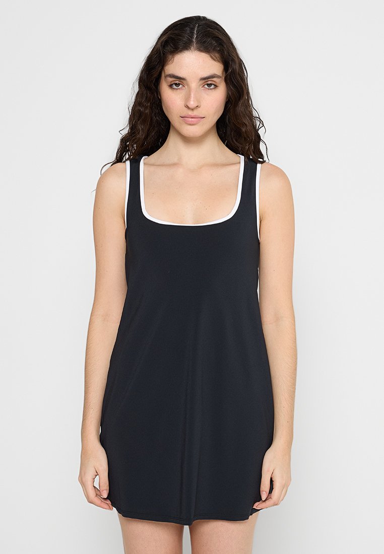 Schwarzes ärmelloses Kleid mit quadratischem Ausschnitt, kontrastierendem weißen Saum und einem glatten, leichten Stoff, der oberhalb des Knies endet.