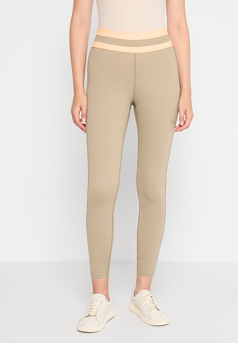 Beige Leggings mit einem hohen, strukturierten Bund, der in hellorange und grau gestreift ist. Hergestellt aus dehnbarem Material, das für Komfort sorgt.