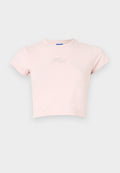 Gekürztes pinkes T-Shirt aus Baumwolle, mit kurzen Ärmeln und einem kleinen silbernen "Hug"-Schriftzug auf der Brust. Glatte Textur, runder Halsausschnitt.