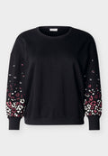 Schwarzer langärmeliger Pullover mit Rundhalsausschnitt und gerippten Bündchen, mit pink-weißem Leopardenmuster auf den unteren Ärmeln.