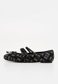 Schwarzer flacher Schuh mit drei Schnallenriemen, verziert mit kleinen weißen Strassmustern und einer Schleife an der abgerundeten Spitze.