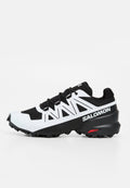 Schwarz-weißer Salomon Trailrunning-Schuh mit robuster Sohle und Markennamen an der Seite, entwickelt für Outdoor-Aktivitäten und guten Grip.