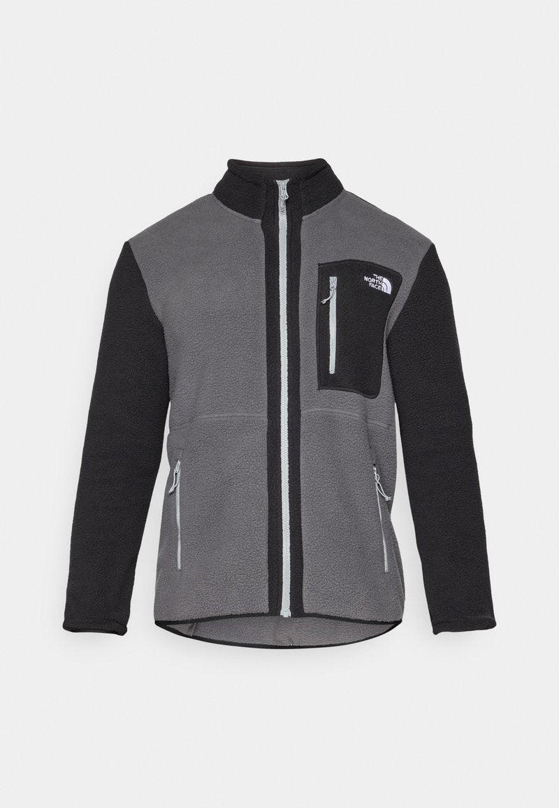 Fleecejacke in Grau und Schwarz mit hohem Kragen, Frontreißverschluss, Brusttasche und zwei Seitentaschen. Mit Kontrastfarbe an den Ärmeln.