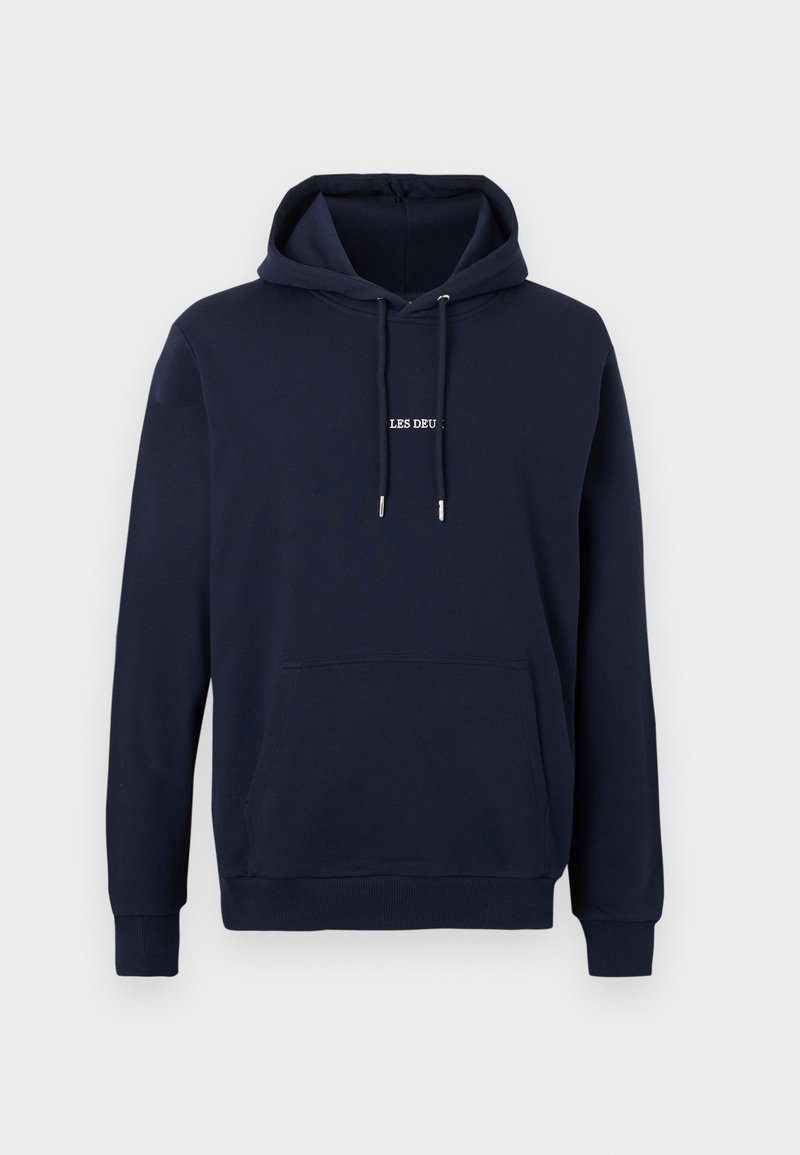 Marineblauer Kapuzenpullover mit Fronttasche, Kordelzugkapuze und kleinem weißen Text "LES DEU" mittig auf der Brust.