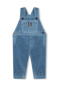 Blaue Corduroy-Kinderlatzhosen mit Fronttasche und verstellbaren Trägern, versehen mit Timberland-Logoaufnäher und Metallknopfdetails.
