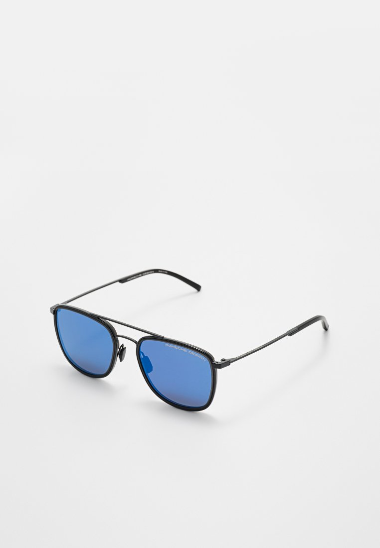 Schwarze Sonnenbrille mit Metallgestell und blau getönten Gläsern sowie verstellbaren Nasenpads, schräg auf weißem Hintergrund.