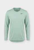 Hellgrünes Nike-Sportshirt mit langen Ärmeln, Rundhalsausschnitt und kleinem schwarzem Nike Swoosh Logo auf der Brust.