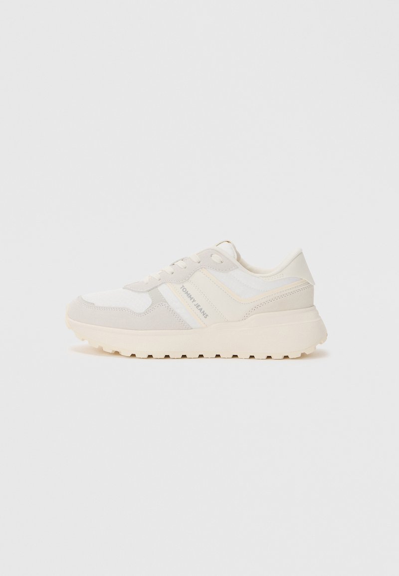 Sneaker in Weiß und Hellbeige mit einer Mischung aus glattem und strukturiertem Stoff. Verfügt über eine gepolsterte Sohle und ein Logo-Detail an der Seite.
