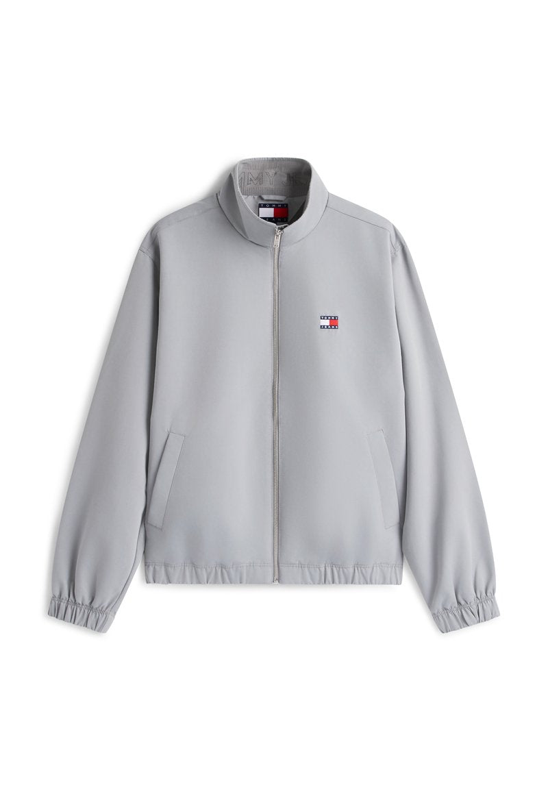 Hellgraue Reißverschlusstjacke mit Stehkragen, elastischen Bündchen und Saum, Seitentaschen sowie kleinem rot-weiß-blauem Logo auf der Brust.