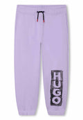 Lilafarbene Sweatpants aus weichem Stoff, mit einem schwarzen grafischen "HUGO"-Druck am linken Bein und einem Kordelzugbund mit roten Akzenten.