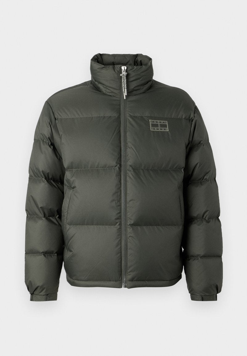 Grüne Puffjacke mit hohem Kragen, Frontreißverschluss, boxy Design und gesteppten Abschnitten. Mit einem kleinen Logodetail auf der oberen Brust.