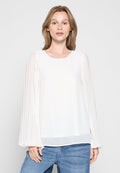 Weißes Blusenshirt mit transparenten, plissierten langen Ärmeln und rundem Halsausschnitt. Glatter Stoff mit lockerem Schnitt, kombiniert mit blauen Jeans.