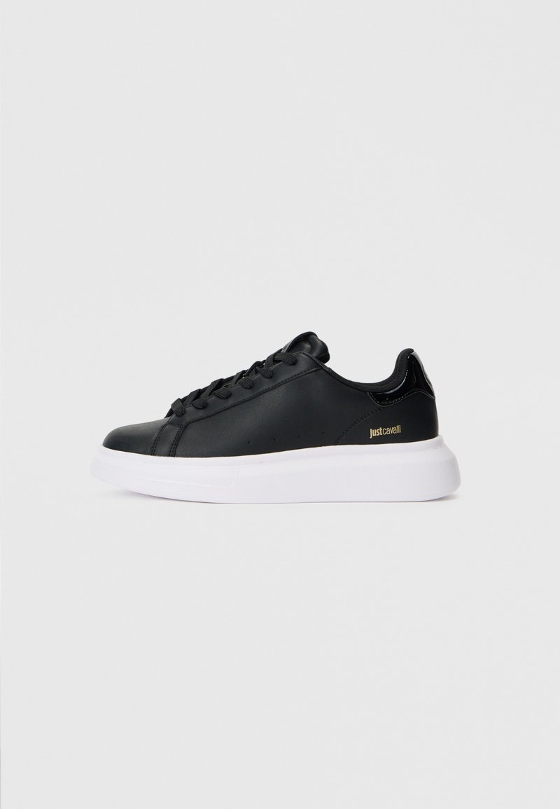 Schwarze Low-Top-Sneaker mit schwarzen Schnürsenkeln, weißer dicker Sohle und kleinem goldenen "Just Cavalli"-Logo an der Seite, im Seitenprofil dargestellt.