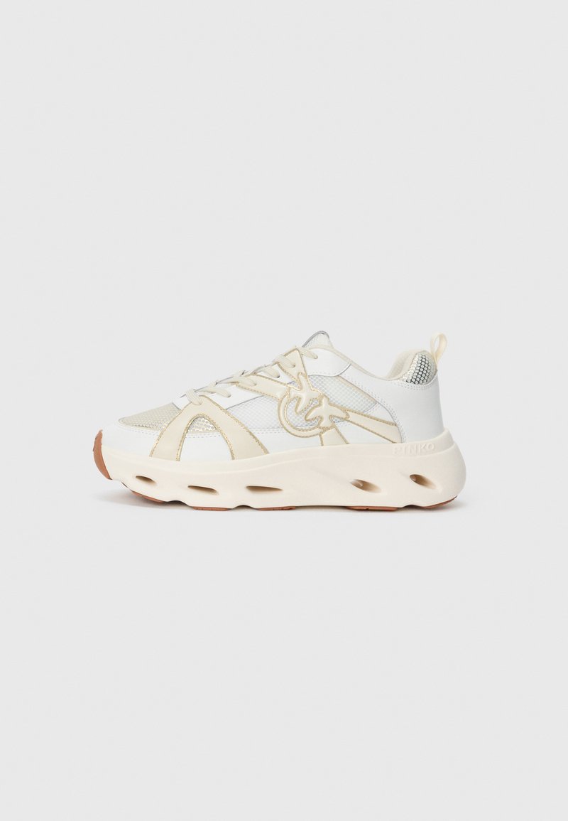 Weißer Sport Sneaker mit strukturiertem Obermaterial, beigen Akzenten, einer dicken Sohle mit Ausschnitten und einem reflektierenden Detail an der Ferse.