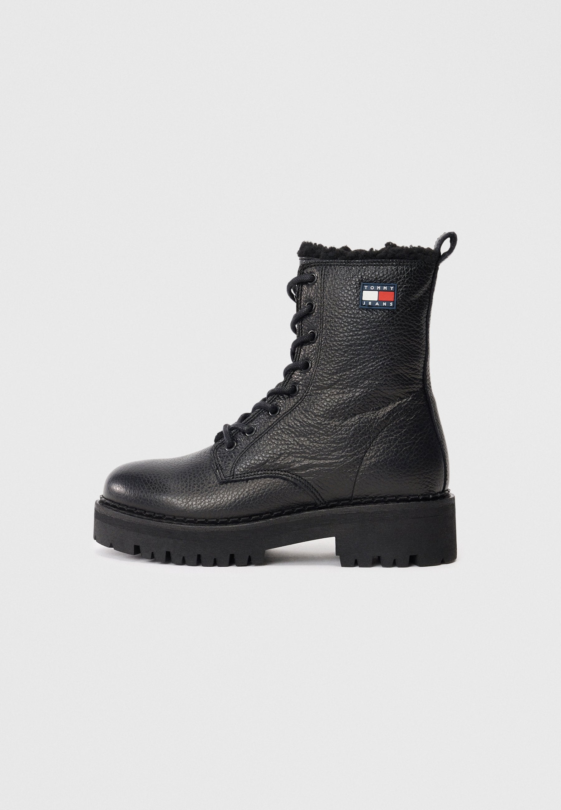 Schwarzer Leder Schnürstiefelette mit strukturiertem Finish, massiver Sohle und einer Kunstfellmanschette. Mit einem Logo-Patch an der Seite.