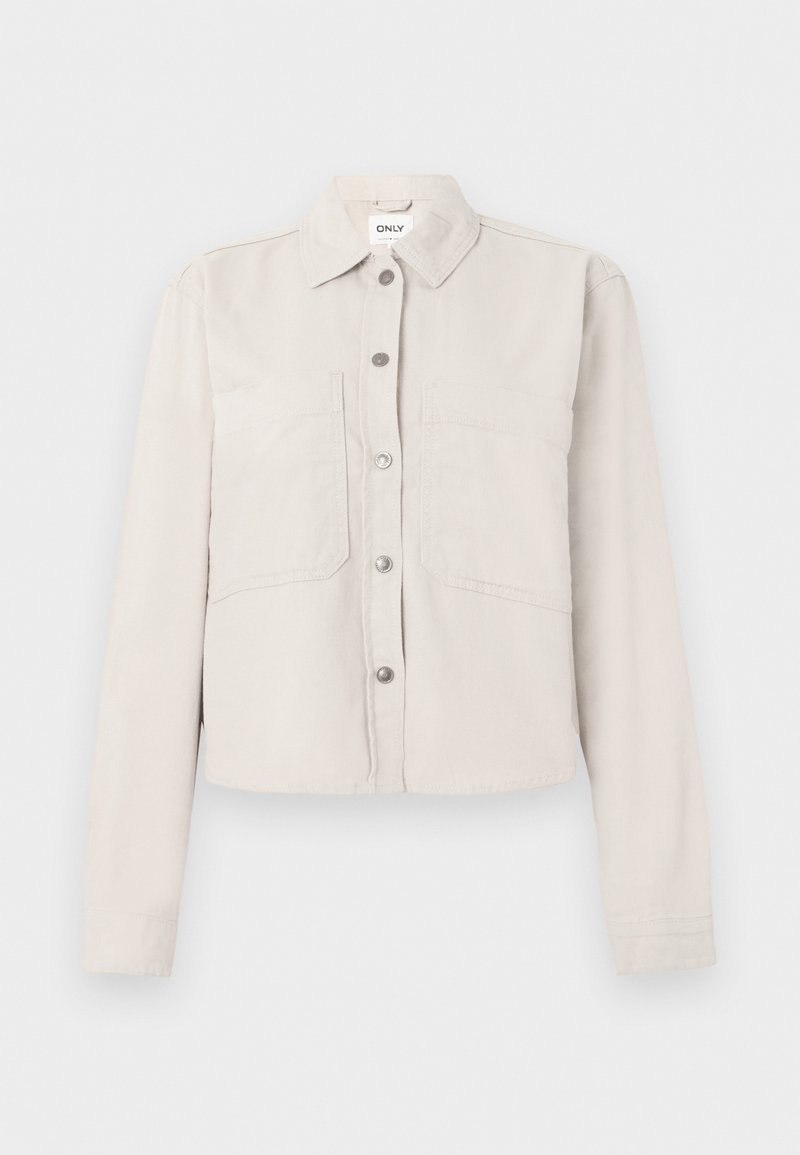 Hellbeige, kurz geschnittene Jacke mit langen Ärmeln, silbernen Druckknöpfen vorne, spitzem Kragen und zwei Brusttaschen.