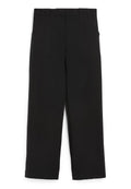 Schwarze weite Hosen aus einem glatten Material, mit zwei vorderen Taschen und einem hohen Bund, entworfen für eine lockere Passform.