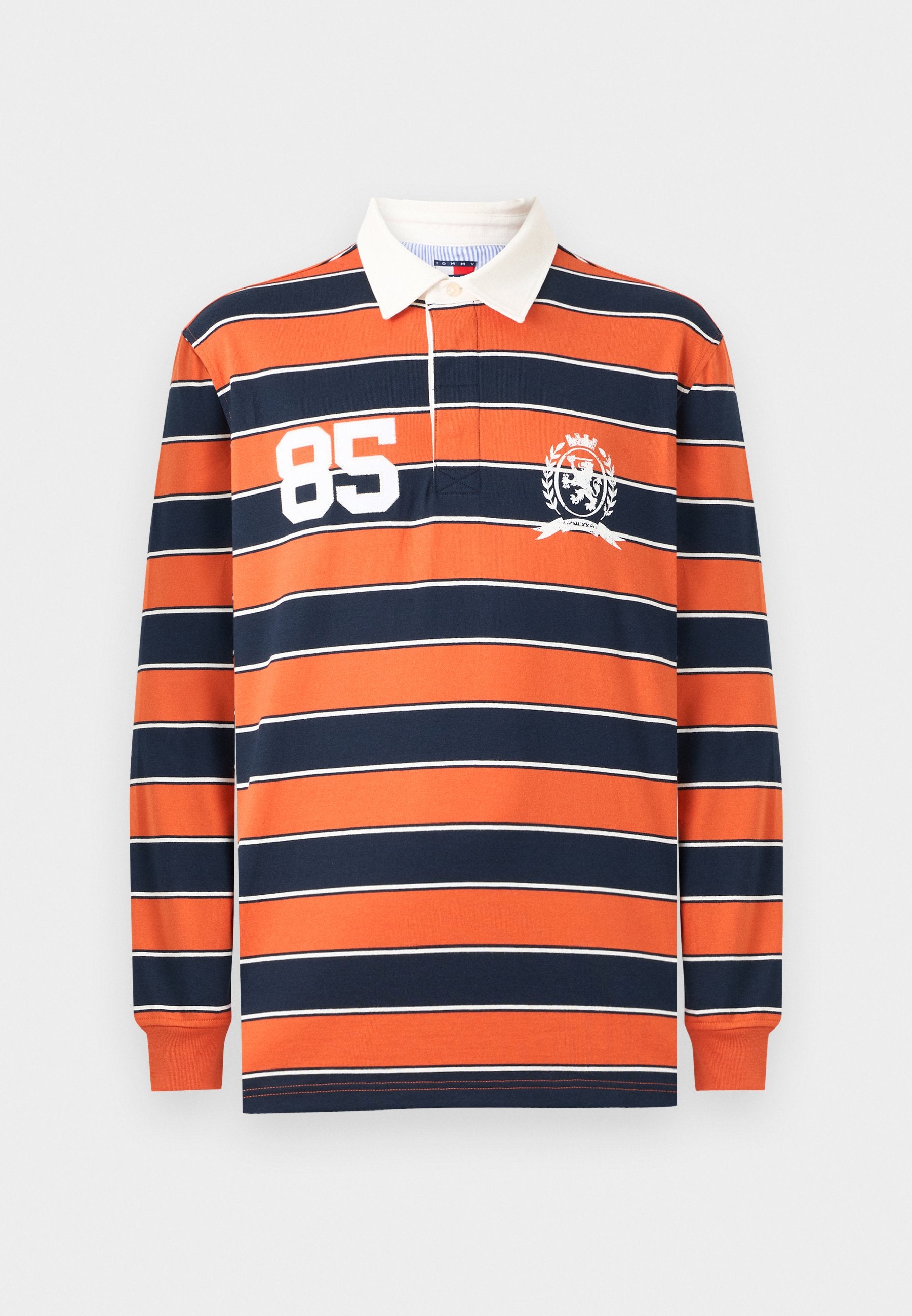Langärmliges Poloshirt mit orangen und marineblauen horizontalen Streifen, weißem Kragen, großem weißen "85" auf der Brust und einem Wappen-Logo an der Seite.
