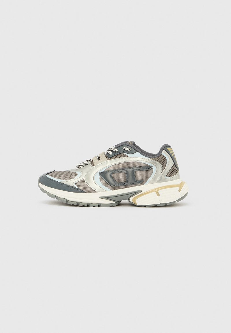 Grauer und beiger Mesh-Sportschuh mit dicker Sohle und gemusterten Schnürsenkeln, seitlich auf weißem Hintergrund gezeigt.