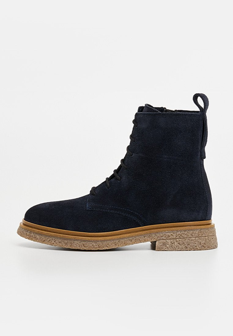 Marineblaue Wildleder-Stiefeletten mit strukturiertem Oberfläche, runder Zehenpartie, Schnürung vorne und Korksohle. Mit einer Schlaufe an der Rückseite für einfaches Anziehen.